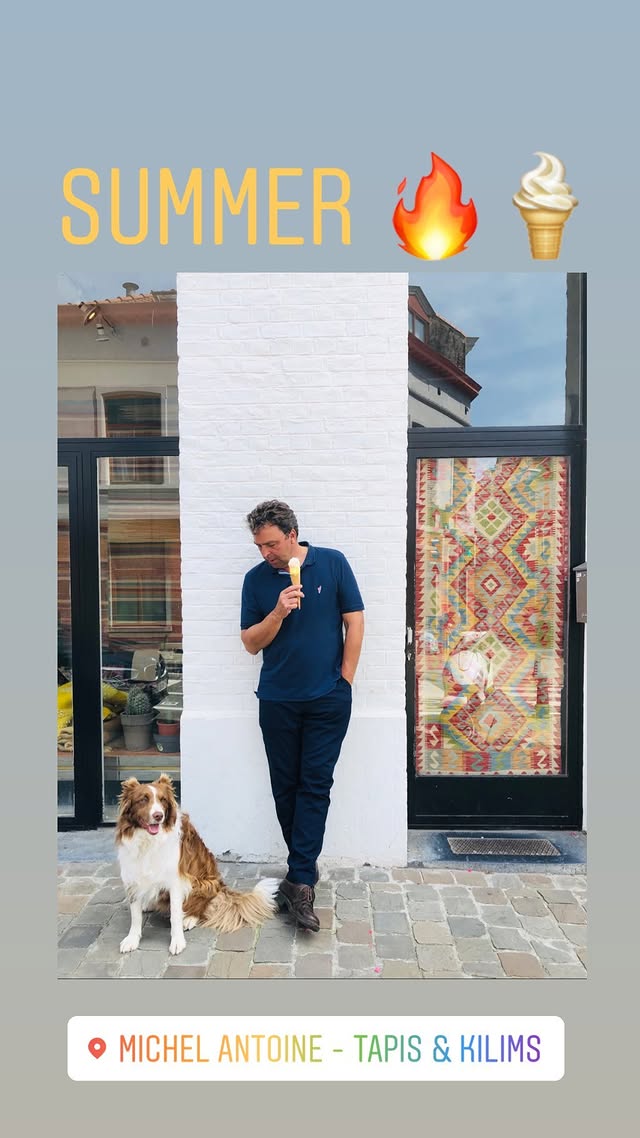 Man met ijsje voor witte muur, hond aan voeten, zomertekst en decoratieve vuur- en ijsiconen.