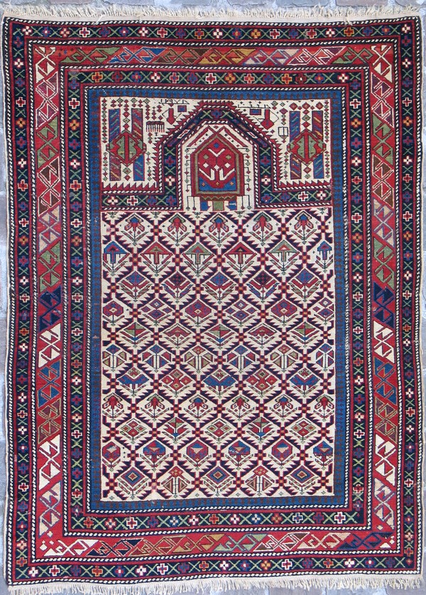 Kleurrijke rechthoekige tapijt met geometrische patronen, randen en kruismotieven in rood, blauw en wit.