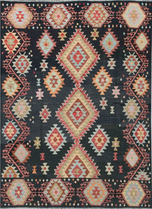 Donkerblauwe kelim met symmetrische ruiten, driehoeken en kleine ornamenten in rood, beige en lichtblauw.